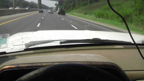 1989 Ford Bronco - Driving on a highway with multiple vehicles visible ahead and to the side.