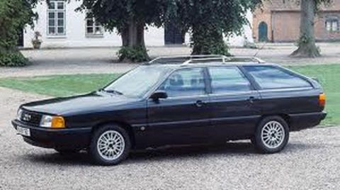 1991 Ford LTD Crown Victoria - This black Audi wagon is seen from the side, parked on a gravel surface in front of a building.