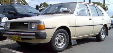 1991 Ford LTD Crown Victoria - This beige hatchback is parked next to a dark SUV in a parking lot.