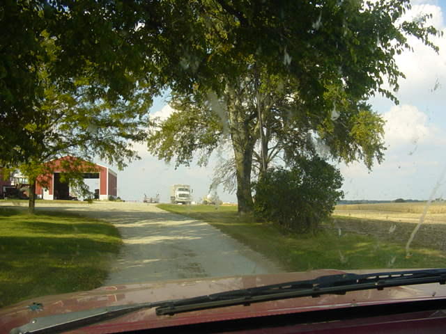 Farm scene with a truck in the distance, seen from a vehicle