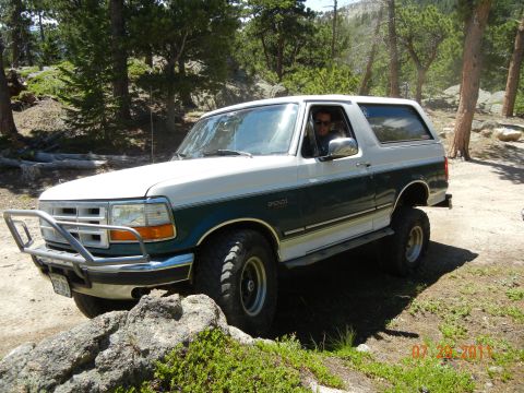 1996 Ford Bronco - A 1996 Ford Bronco is shown off-road with a brush guard and lifted suspension.