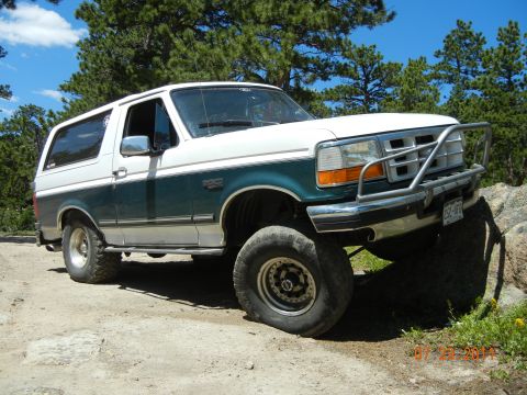 1996 Ford Bronco - This 1996 Ford Bronco is shown off-roading on a dirt path with large rocks.