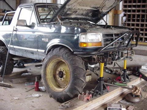 1992 Ford Bronco - This Ford Bronco is undergoing modifications in a workshop, a lifted suspension and aftermarket bumper.
