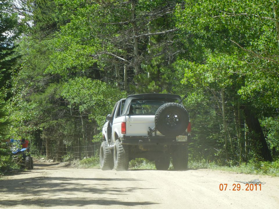 1996 Ford Bronco rear view, white, with spare tire on back, on dirt road