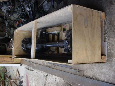 1992 Ford Bronco - A differential axle is packed inside a wooden crate, with other parts visible in the background.