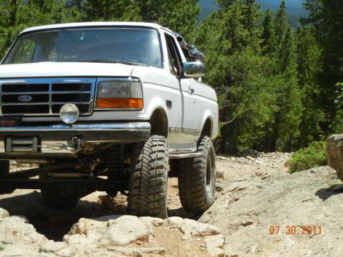1996 Ford Bronco - This white Ford F-Series truck navigates a challenging rocky terrain, with a date stamp indicating it was photographed on July 30, 2011.