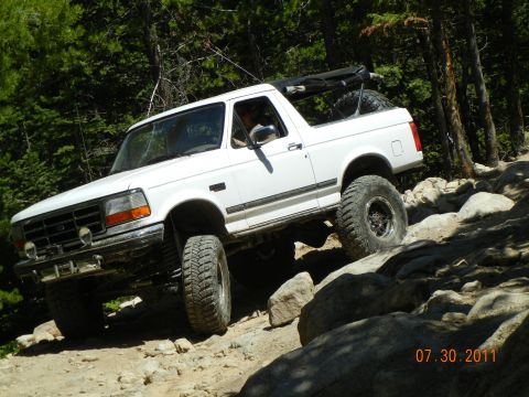 1996 Ford Bronco - 1996 Ford Bronco navigates a challenging rocky terrain on an off-road trail.