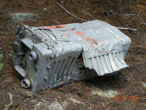 1996 Ford Bronco - A damaged metal object, possibly a radiator or heat exchanger, lies on the forest floor.