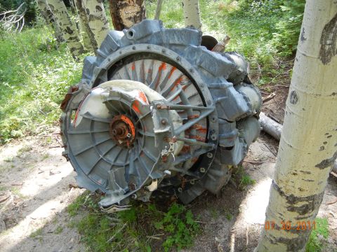 1996 Ford Bronco - A damaged engine turbine, likely from an aircraft, lies on the forest floor.