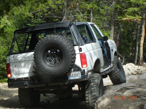 1996 Ford Bronco - White 1996 Ford Bronco navigates rocky terrain off-road.
