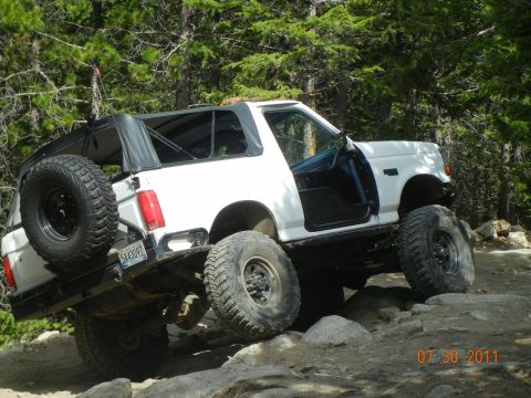 1996 Ford Bronco - This 1996 Ford Bronco is navigating a rocky trail with its doors removed and soft top in place.