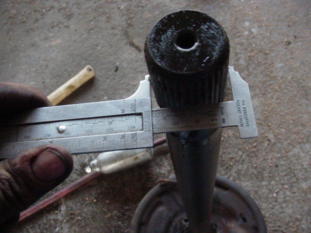 Measuring black cylindrical part with calipers