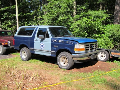 1991 Ford Crown Victoria LTD - This two-tone blue Ford Bronco is parked next to a red Jeep and a trailer.