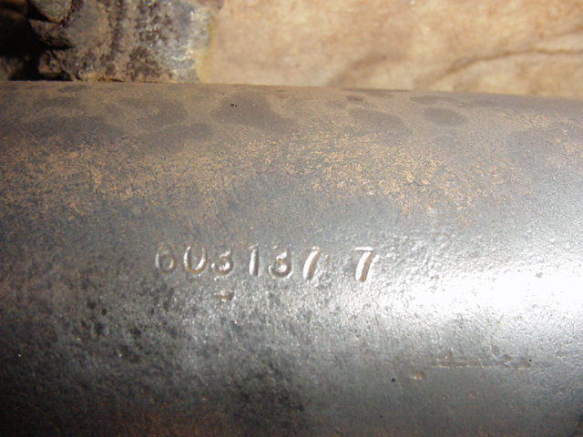 Close-up of a metal tube with stamped numbers 603137 7. Supermotors.net logo in corner