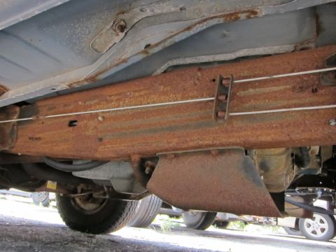 1991 Ford LTD Crown Victoria - Undercarriage view shows significant rust on the frame and suspension components of a vehicle.
