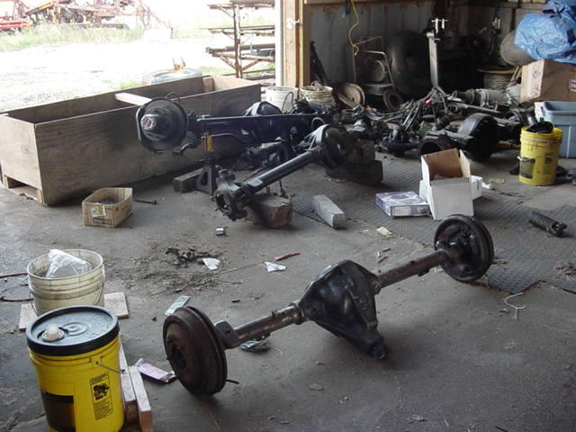 Vehicle axles on a concrete floor with buckets and wooden crates