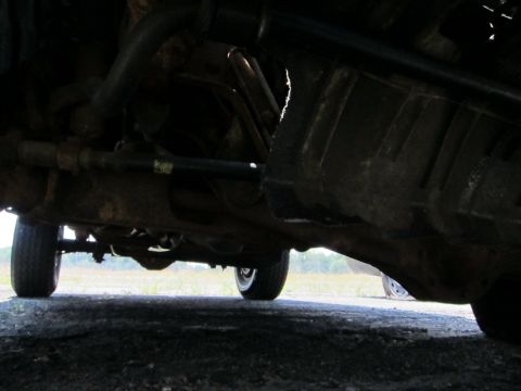 1991 Ford LTD Crown Victoria - The underside of a vehicle is captured from a low angle, revealing mechanical parts and tires.