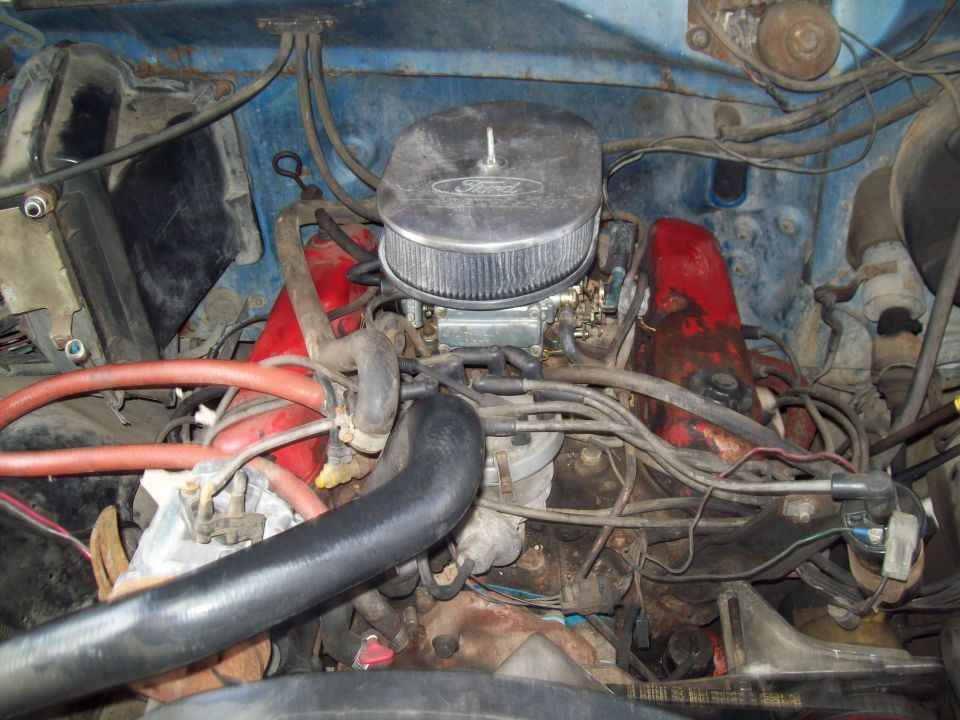 V8 engine with red valve covers and chrome Ford air cleaner in a blue Bronco's engine bay