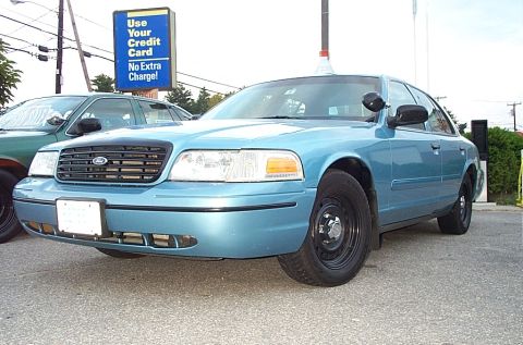 2001 Ford Crown Victoria - Front 3/4 view of a light blue 2001 Ford Crown Victoria, parked outdoors.
