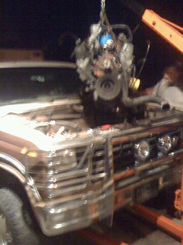 1988 Ford Bronco - Engine removal from a truck with a prominent chrome grille and open hood.