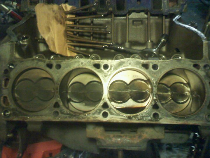 Engine block showing pistons and valves. A rag is stuffed into the top