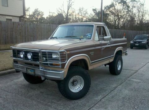 1988 Ford Bronco - This lifted Ford Bronco has a two-tone brown paint job and a chrome grille guard.