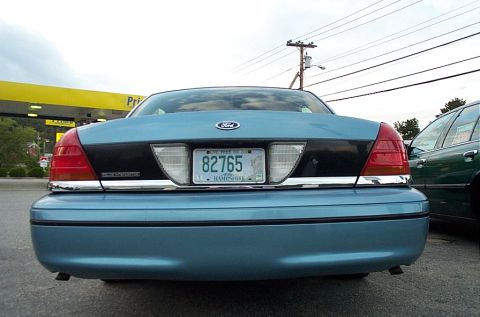 2001 Ford Crown Victoria - Rear view of a blue 2001 Ford Crown Victoria parked next to another vehicle.