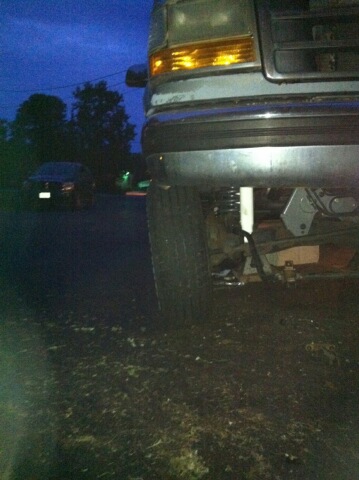 1993 Ford Bronco - The front corner of a truck is visible, with another vehicle in the distance as the sky darkens.