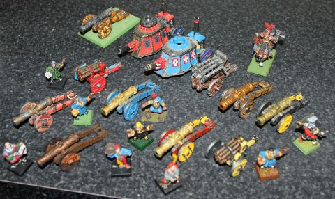 1978 Chevrolet C/K Pickup - A variety of miniature cannons and figures are arranged on a dark, textured surface.