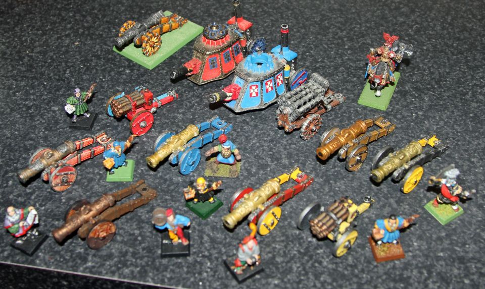 Array of painted fantasy miniature cannons, war machines and crew figures