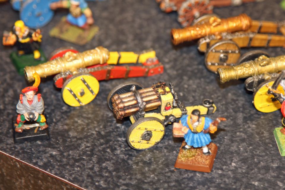 Painted miniature wargame cannons and crew figures on a granite countertop