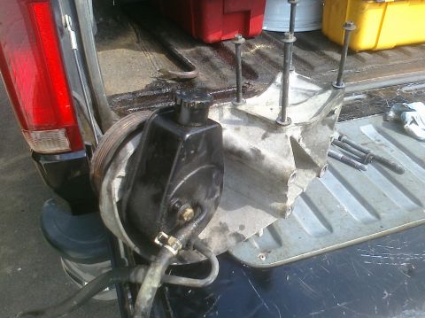 1995 Ford Bronco - A power steering pump and transmission housing are shown in the bed of a pickup truck.