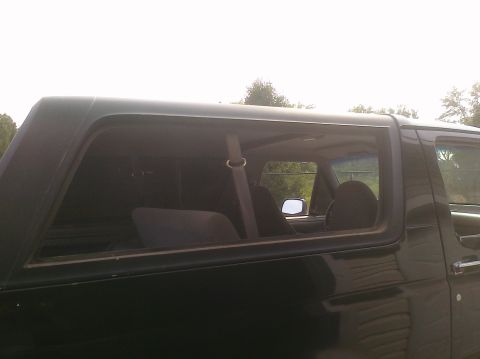 1995 Ford Bronco - Side view of a 1995 Ford Bronco, revealing its interior and dark green exterior.