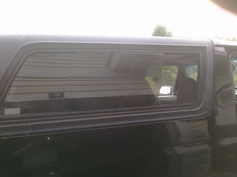 1995 Ford Bronco - Side profile of a dark SUV, focusing on the rear passenger window and body panel.