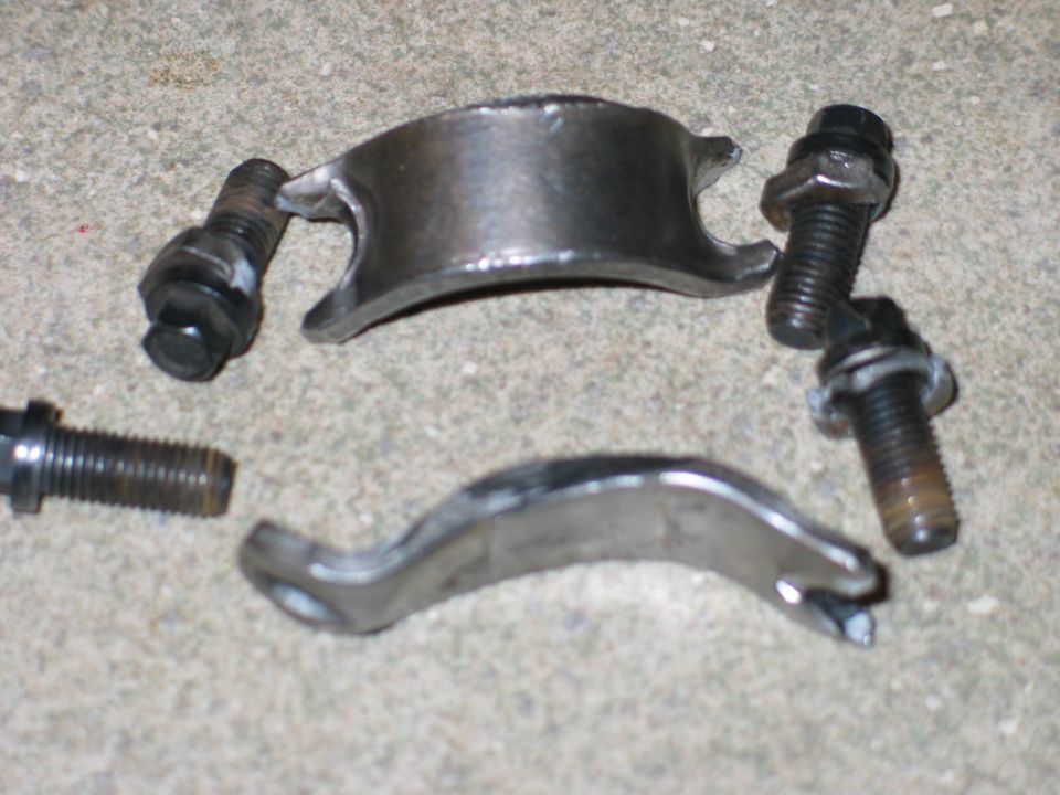 Metal automotive parts and bolts on a concrete surface