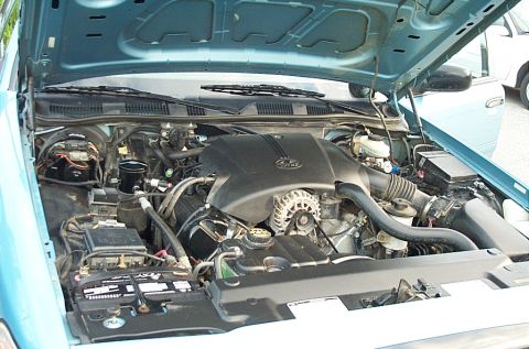 2001 Ford Crown Victoria - The engine compartment of a light blue 2001 Ford Crown Victoria is open for inspection.