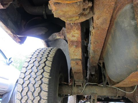 1991 Ford LTD Crown Victoria - Undercarriage view shows significant rust on leaf springs and suspension components, with a tire visible.
