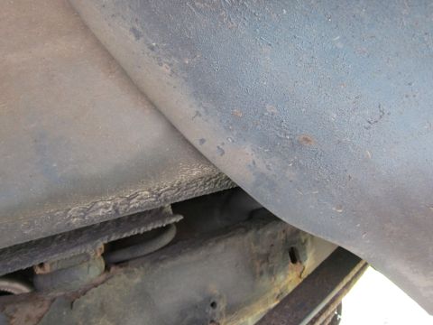 1991 Ford LTD Crown Victoria - Close-up view of the undercarriage, revealing the frame, suspension, and a portion of the vehicle's body.