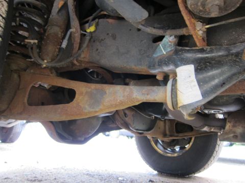 1991 Ford LTD Crown Victoria - Close-up of the underbody, showing suspension and drivetrain parts with visible rust.