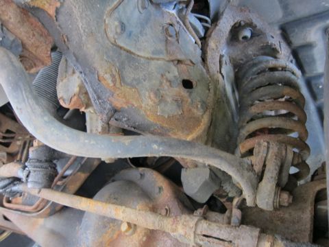 1991 Ford LTD Crown Victoria - Close-up view of heavily rusted suspension parts, showing significant wear and corrosion.