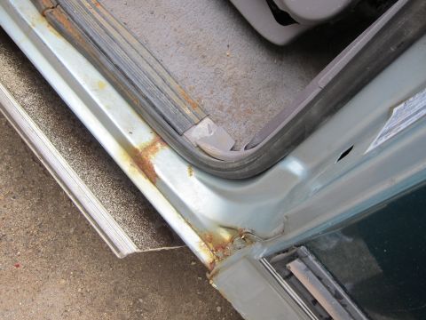 1991 Ford LTD Crown Victoria - Close-up of a car's interior door sill, showing signs of rust and wear.