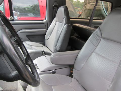 1991 Ford LTD Crown Victoria - Gray bucket seats and center console inside a pickup truck, with another vehicle seen through the window.