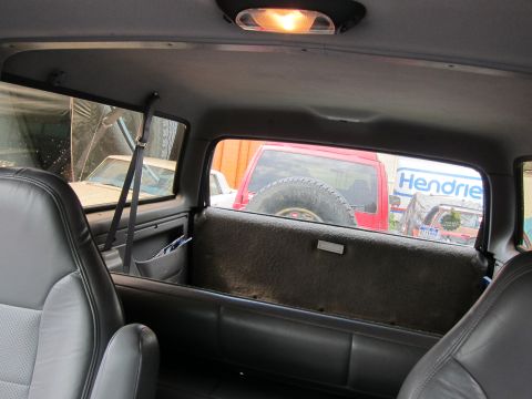 1991 Ford LTD Crown Victoria - View from inside a vehicle, looking past the rear seats towards other vehicles outside.