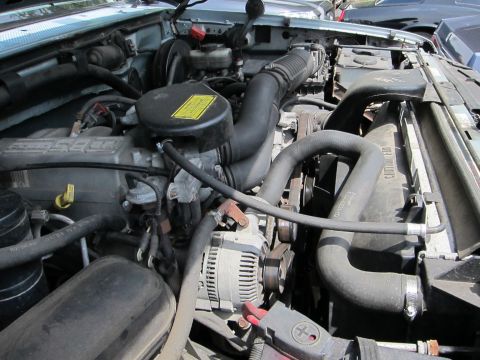 1991 Ford LTD Crown Victoria - Close-up view of an engine bay, showing various components like hoses, the alternator, and the air intake system.
