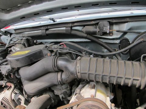 1991 Ford LTD Crown Victoria - Close-up view of an engine bay, showing various hoses and mechanical components.