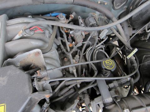 1991 Ford LTD Crown Victoria - Close-up view of an engine bay, showing intricate wiring and plumbing.