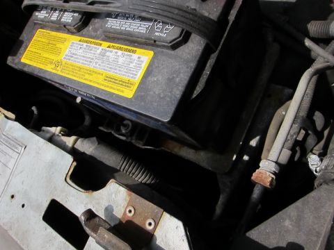 1991 Ford LTD Crown Victoria - Close-up view of a car battery and surrounding engine bay components.