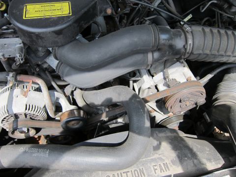 1991 Ford LTD Crown Victoria - Close-up view of an engine bay, showing various components like the alternator, belts, and hoses.