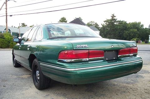 2001 Ford Crown Victoria - Rear view of a green 2001 Ford Crown Victoria sedan with chrome accents and black wheels.