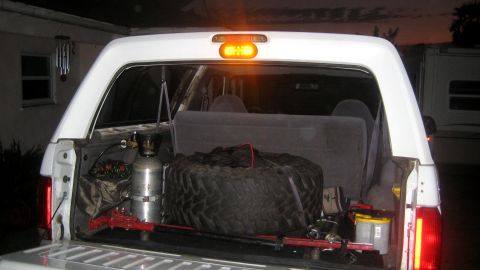 1996 Ford Bronco - The rear cargo area of a 1996 Ford Bronco is visible, equipped with a spare tire and other gear.